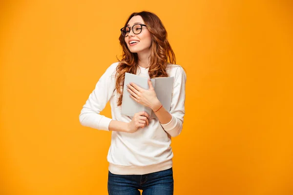 Mujer morena agradable en jersey y gafas abrazando libro —  Fotos de Stock