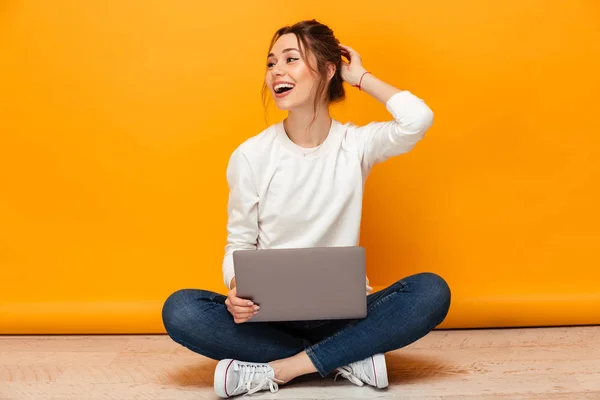 Happy brunette woman in sweater sitting on the floor — Stock Photo, Image