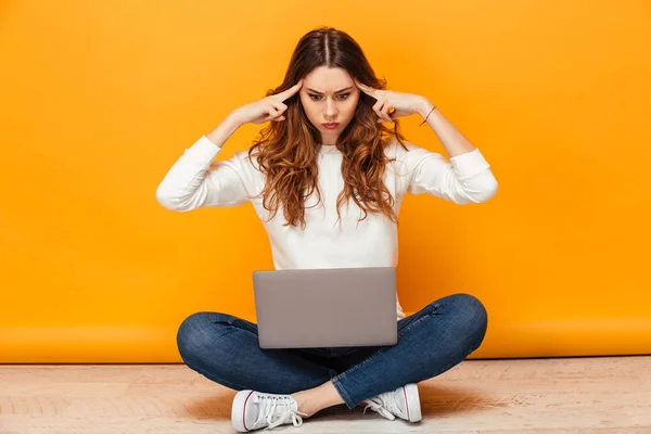 Thoughtful brunette woman in sweater sitting on the floor — Stock Photo, Image