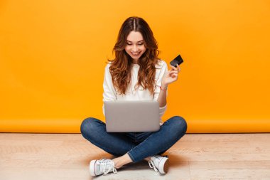 Gülümseyen kazaklı katta oturan esmer kadın