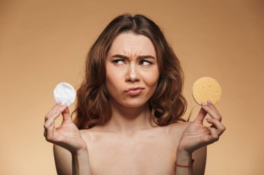 Genç kadın sünger ve pamuk arasında tercih pad