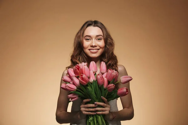 Nadšený, krásná mladá žena držící květiny tulipány — Stock fotografie