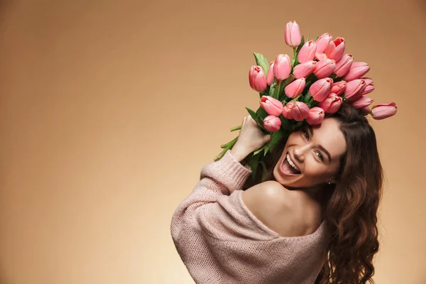 Upphetsad skrikande vackra unga kvinna som håller tulpaner blommor — Stockfoto