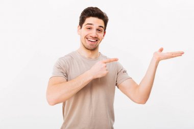 Genç adam rahat t-shirt fotoğraf makinesi geniş gülümseme ile poz içinde bir
