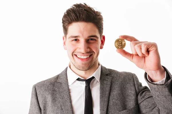 Portrait of a happy young businessman showing golden bitcoin — Stock Photo, Image