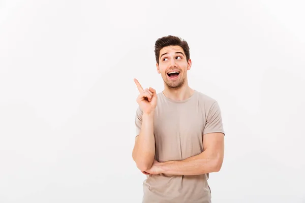 Positiver brünetter Mann 30 trägt beiges T-Shirt, der Finger gestikuliert — Stockfoto