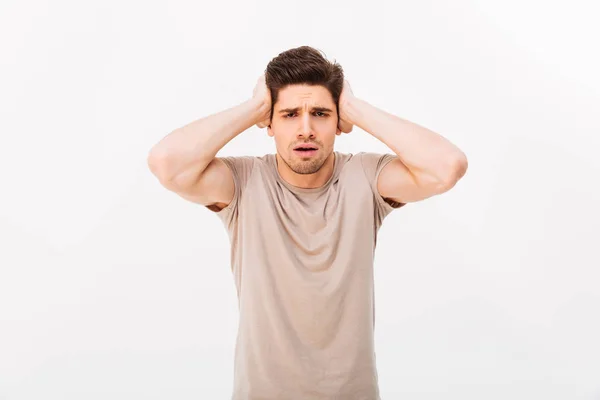 Photo of muscular adult man 30s grabbing his head or covering ea — Stock Photo, Image