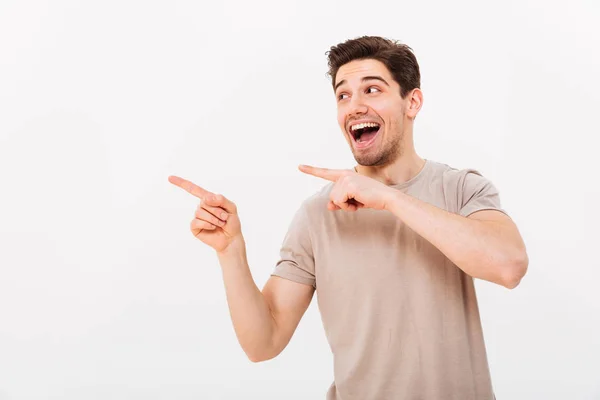 Image de l'homme satisfait en t-shirt décontracté se réjouissant et pointant — Photo