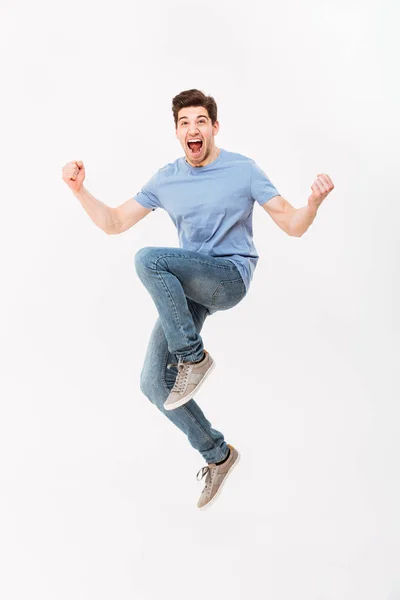 Foto de larga duración del hombre excitado de 30 años en camiseta casual y jeans —  Fotos de Stock