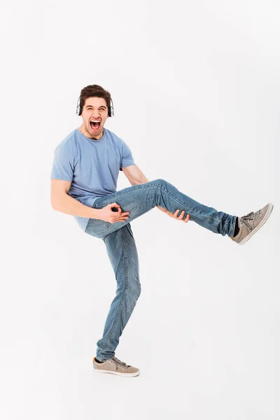 Full-length photo of joyous guy listening to music via headphone — Stock Photo, Image