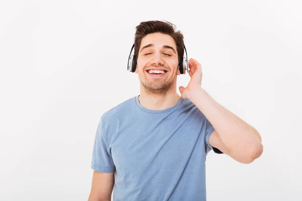 Foto van volwassen Glimlachende man met kort donker haar genieten van muziek — Stockfoto