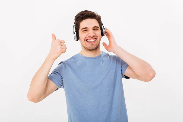 Memnun adam rahat t-shirt kulaklık ile müzik dinlemek — Stok fotoğraf