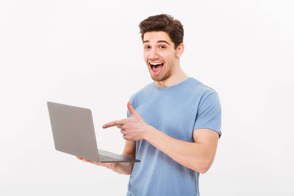 Imagem de cara alegre em t-shirt casual segurando prata noteboo — Fotografia de Stock