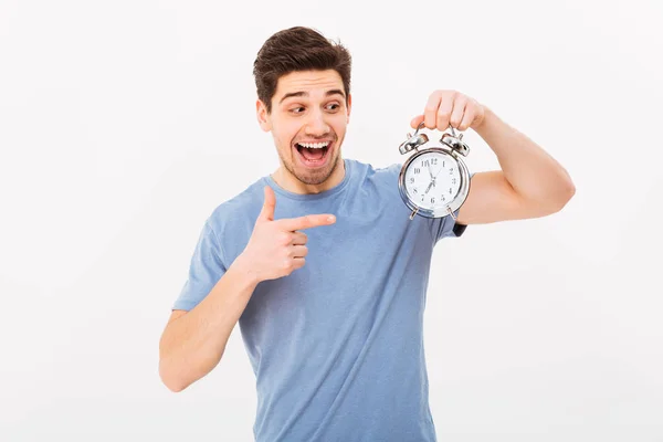 Jovem animado homem em t-shirt casual e segurando e apontando barbatana — Fotografia de Stock