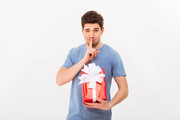 Zdjęcie z przystojny mężczyzna trzyma prezent urodzinowy i prośbą, aby zachować s — Zdjęcie stockowe