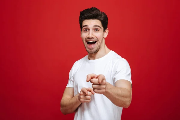 Retrato de um jovem sorridente de camiseta branca apontando o dedo — Fotografia de Stock