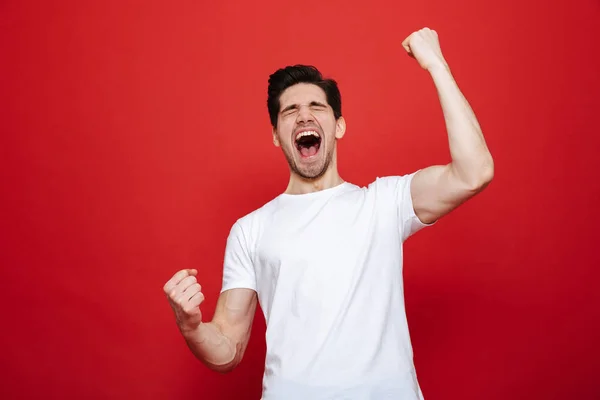 Retrato de un joven alegre en camiseta blanca celebrando — Foto de Stock