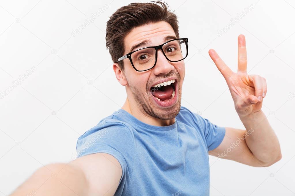Joyful man in t-shirt and eyeglasses making selfie