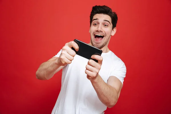 Portret van een enthousiast jonge man in het witte t-shirt spelen — Stockfoto