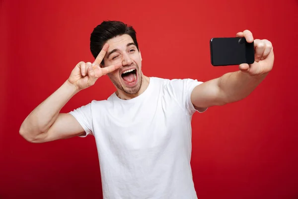 Porträtt av en upphetsad ung man i vit t-shirt — Stockfoto