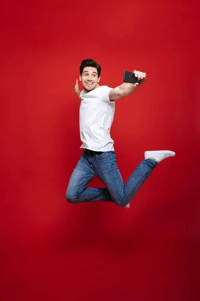 Retrato de comprimento total de um jovem sorridente em camiseta branca — Fotografia de Stock