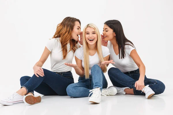 Porträtt av tre glada casual tjejer dela hemligheter — Stockfoto