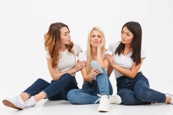 Retrato de tres chicas ocasionales disgustadas sentadas juntas — Foto de Stock