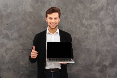 Neşeli işadamı gösteren ekran dizüstü başparmak makyaj.