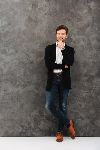 Glad ung affärsman står över grå vägg — Stockfoto