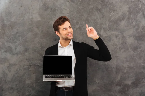 Šťastný podnikatel ukazující zobrazeno zobrazení přenosného počítače. — Stock fotografie