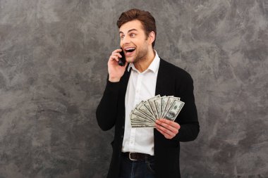 Para bir yana cep telefonuyla konuşurken seyir holding neşeli genç işadamı.