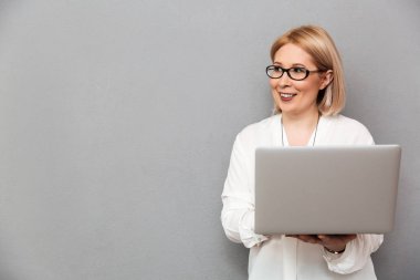 Gömlek ve gözlük gülümseyen orta yaşlı sarışın kadın