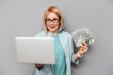 Bluz ve para tutan gözlük gülümseyen orta yaşlı sarışın kadın