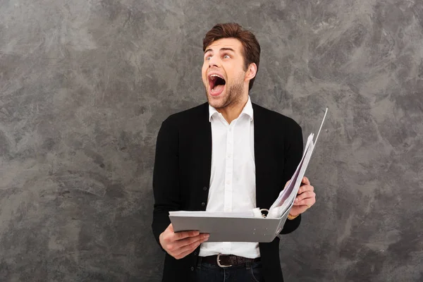 Screaming businessman standing over grey wall — Stock Photo, Image