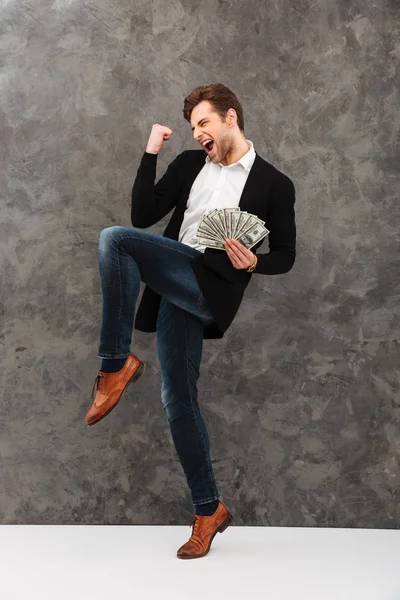 Emocionado joven empresario sosteniendo el dinero hacer gesto ganador . —  Fotos de Stock