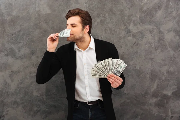 Χαρούμενος νεαρός επιχειρηματίας μυρωδιά χρήματα. — Φωτογραφία Αρχείου