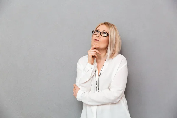 Pensive middle-aged blonde woman in shirt and eyeglasses — Stock Photo, Image