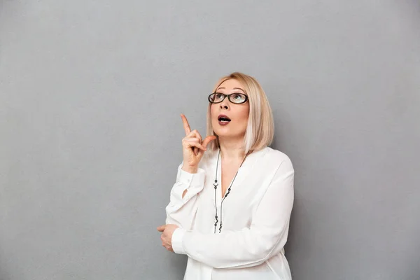 Pensativa mujer rubia de mediana edad en camisa y gafas teniendo idea — Foto de Stock