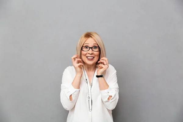 Mujer rubia de mediana edad sorprendida en camisa y gafas se regocija —  Fotos de Stock