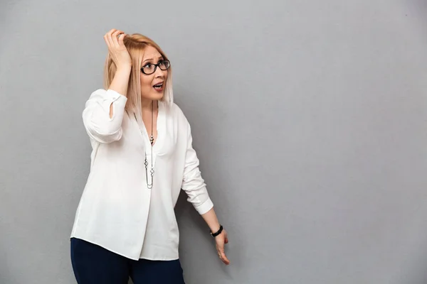 Bingung wanita pirang paruh baya dengan kemeja dan kacamata — Stok Foto
