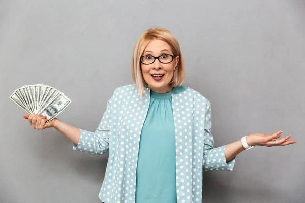 Confused happy middle-aged blonde woman in blouse and eyeglasses — Stock Photo, Image