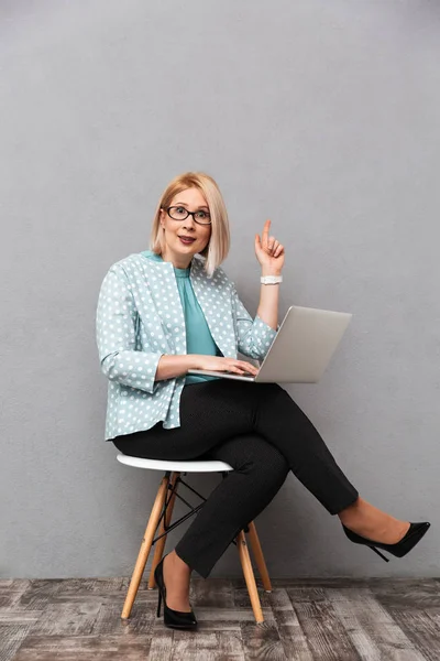 Mujer de negocios impactada usando computadora portátil apuntando tienen una idea . — Foto de Stock