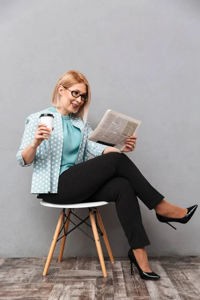 Mulher de negócios alegre beber café leitura jornal . — Fotografia de Stock