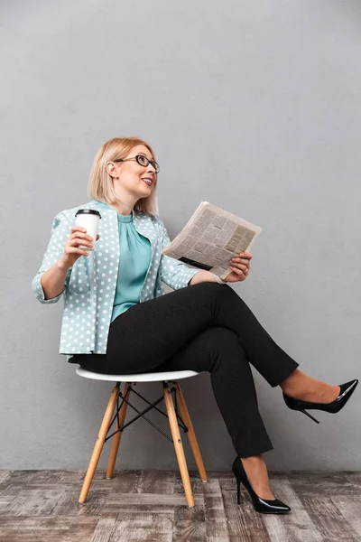 Alegre mujer de negocios beber café leyendo periódico . — Foto de Stock