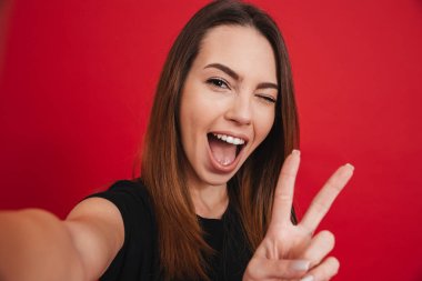 Sevimli kadın 20'li yaşlarda eğleniyor ve selfie zekâ alarak siyah t-shirt