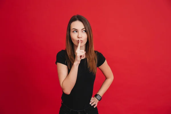 Portrait of beautiful charming woman holding index finger on lip — Stock Photo, Image