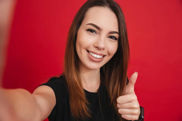 Jovem mulher feliz 20s com cabelos castanhos longos sorrindo e tomando se — Fotografia de Stock