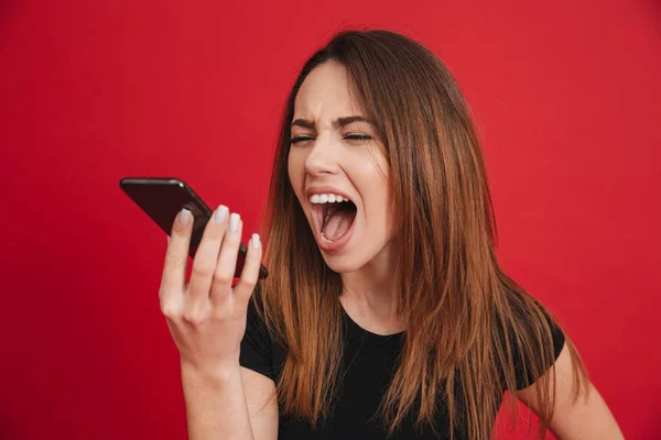 Foto de mujer morena furiosa gritando en el teléfono mientras tiene — Foto de Stock