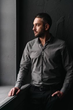 Yakışıklı adam koyu arka plan üzerinde ayakta