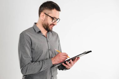 Yakışıklı işadamı panosu yazılı notlar tutarak.